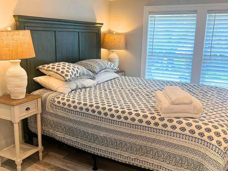 Nice Queen-sized bed with bright windows.