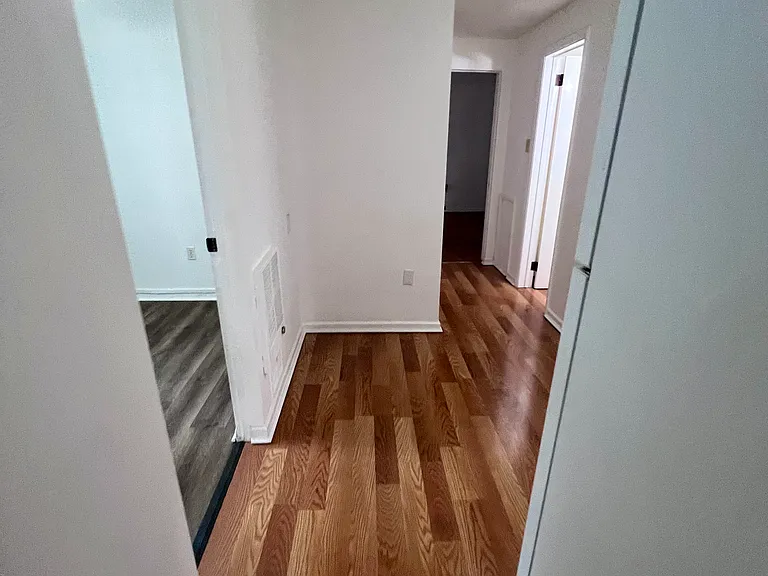 Small bedroom on left, kitchen to the right, hallway ahead to large bedroom, bathroom, and hallway closets.