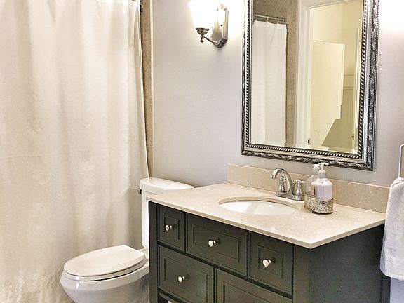 Bathroom with tiled floor and shower .