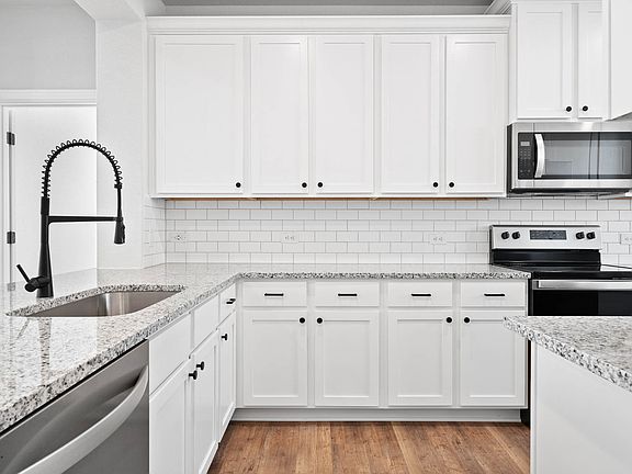 The kitchen has beautiful white cabinetry.