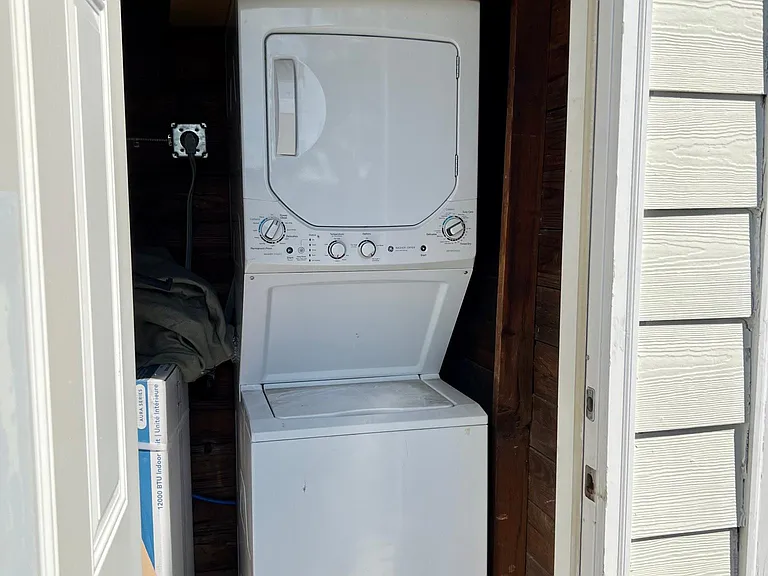 Individual Stacked Laundry room with hot water heater.