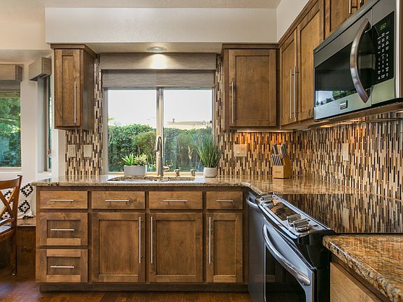 Well appointed kitchen with microwave, electric stove, dishwasher, disposal and nice view of the backyard.