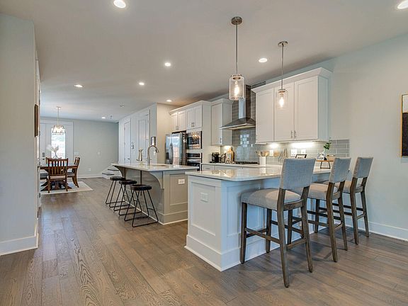 Large open kitchen with gas stove and 2 bar seating areas.