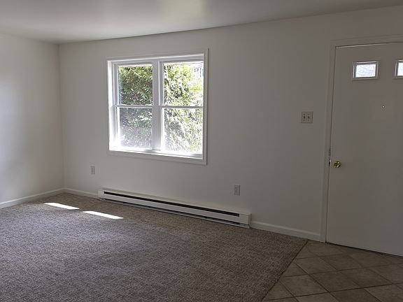 Living room with tile floor from doorway to kitchen.