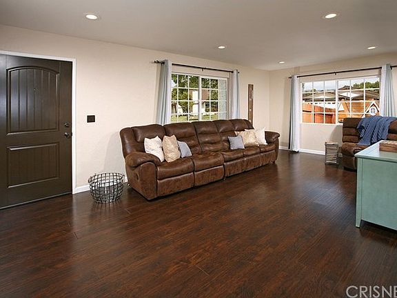 The impressive living room is bathed in natural light from a multitude of windows and is further accented by modern recessed lighting and striking contemporary wood flooring.