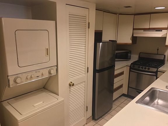 Kitchen with washer/dryer and floor-to-ceiling pantry cabinet.