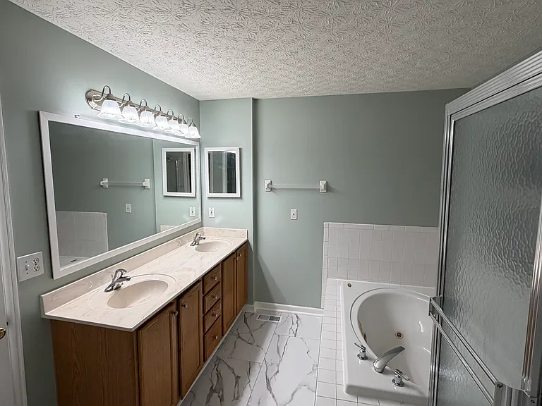 Double vanity with large mirror and new lighting (2026) in the master bath.