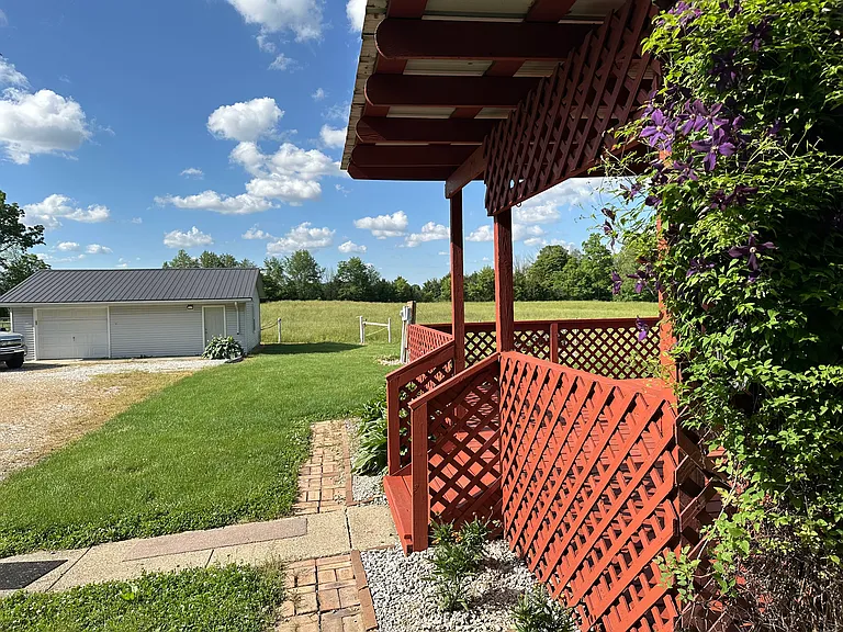 Driveway, garage and side entrance with wrap around deck and partial cover
