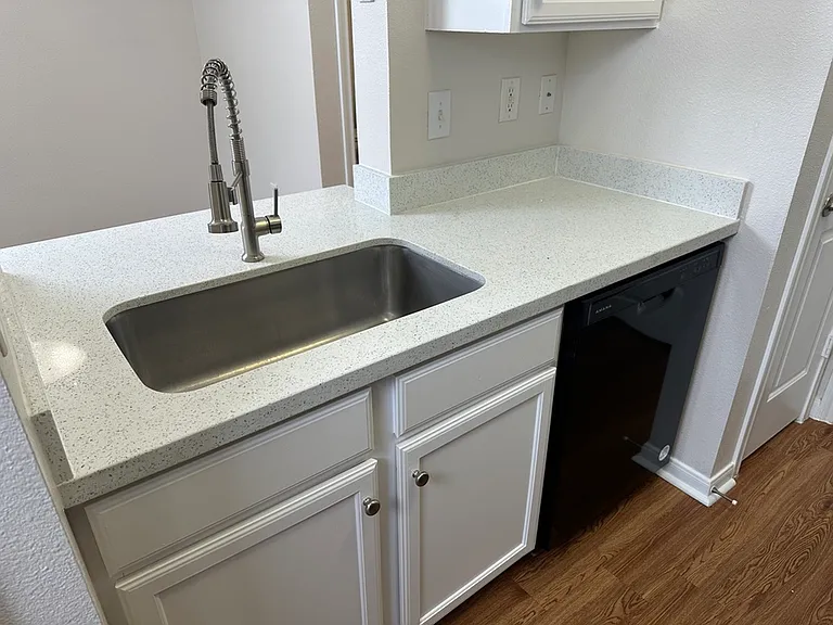 Modern kitchen with sleek stainless steel sink, quartz countertop, and integrated dishwasher. Modern kitchen with sleek stainless steel sink, quartz countertop, and integrated dishwasher.