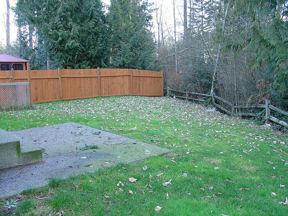 Large serene backyard with greenbelt behind for privacy.