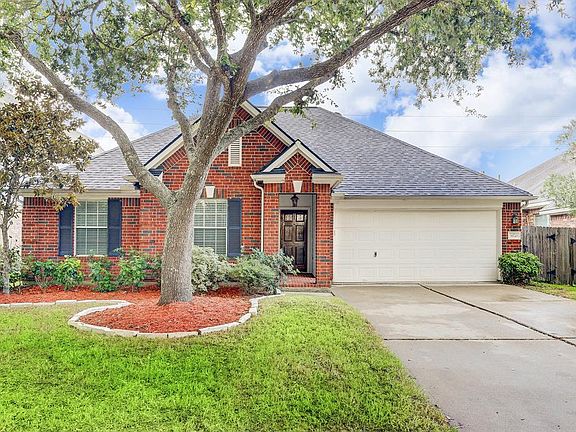 Shutters accent the windows and compliment the three sided brick home.