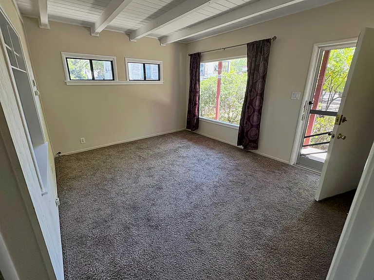 Living room/front room with entry door to the right and large picture window to the left of the door.