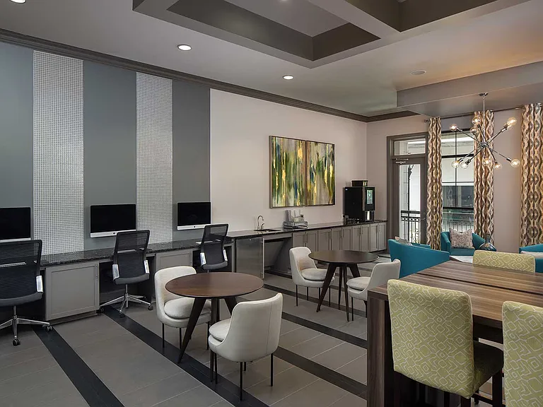 lounge area with imac computers, coffee machine, and various tables and seating areas.