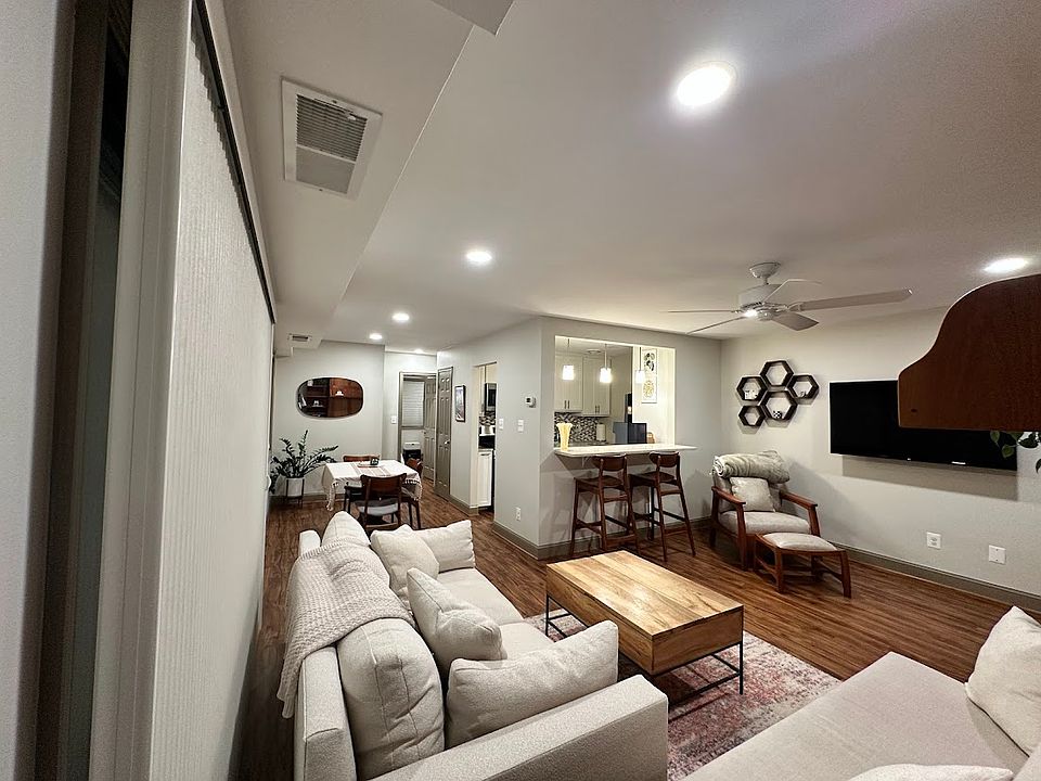 Newly remodeled open concept living room, breakfast bar, mounted smart TV, and dining area with luxury finishes.