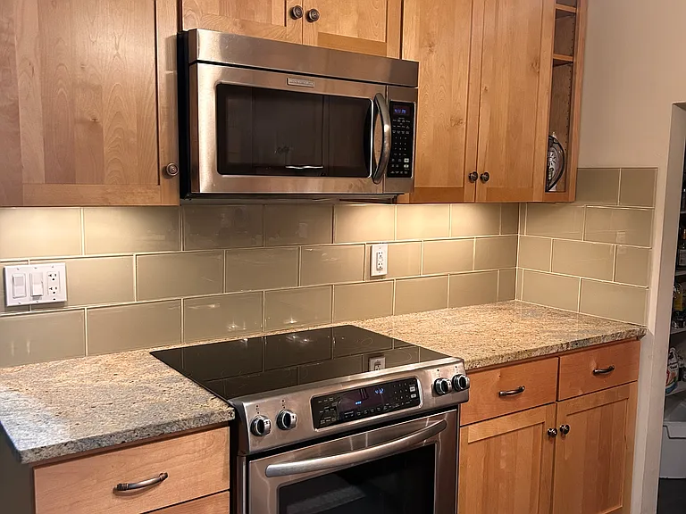 Kitchen with KitchenAid appliances, granite countertops and ample space.