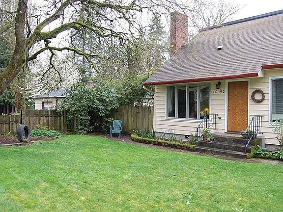 Front of house with tire swing on large locust tree