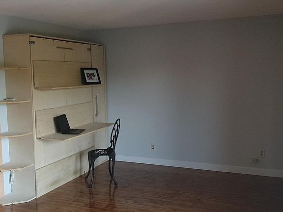 living room with custom murphy bed - convertible office space to a guest bed