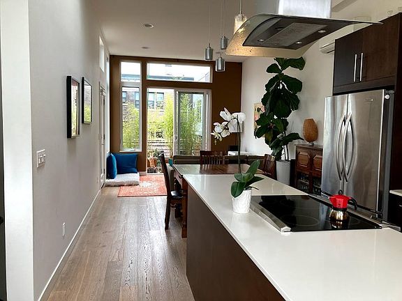 kitchen in foreground with living/dining behind. Sliding glass doors (with a screen) allow plenty of light