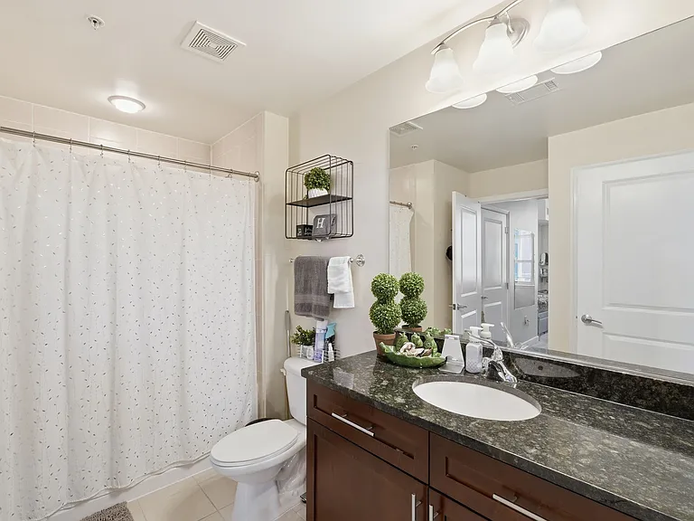 Primary bathroom featuring a spacious vanity, granite countertop, and updated fixtures