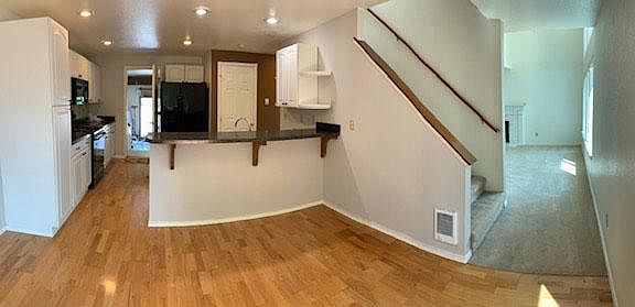 Kitchen view from dining area Stair on right to bedrooms and two bathrooms plus linen closet Garage door at back of kitchen