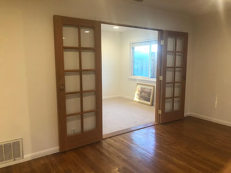 Bedroom #4 or home office with a double wooden French Door, new carpet and fresh wall paint