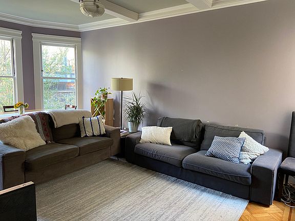 Large living room that looks out onto the shared backyard, with lots of natural light