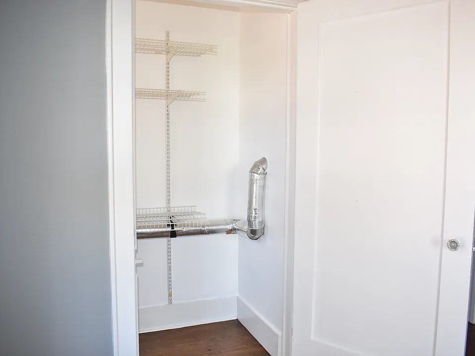Oversized walk in closet with shelving for storage.