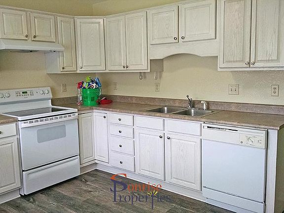 Kitchen cabinets, stove, sink, and dishwasher.