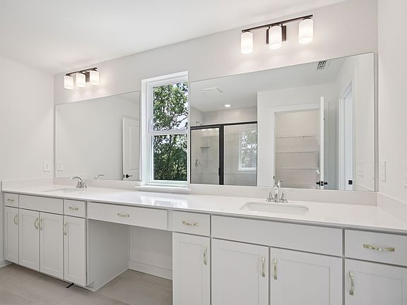 The primary bathroom offers dual vanity sinks and a walk-in shower.