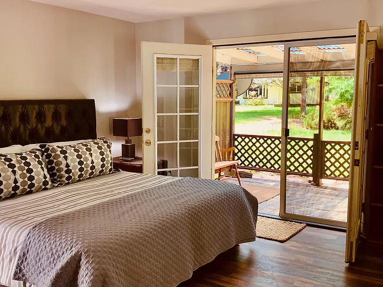 After a wonderful night of sleep in the main bedroom, you wake up to a gorgeous view. There is lots of space, French doors to the back patio, and a view of the open green grass and trees!