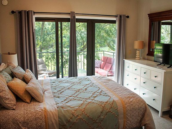 This queen bedroom has a wall of windows overlooking the golf course and a new mattress.