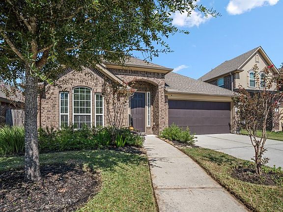 Beautiful shade tree in the front landscaped yard as you walk up to the front door of the home.