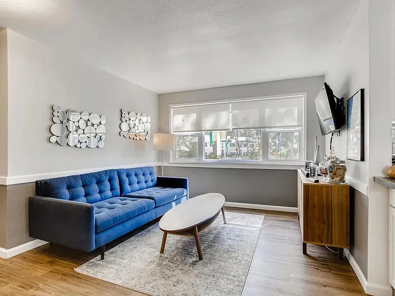 A living room with a blue couch and a wooden coffee table.