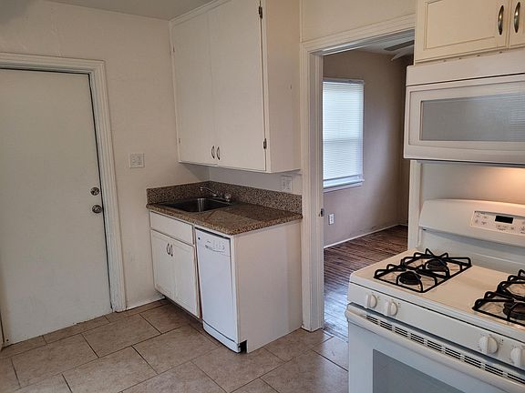 Kitchen with view to Bedroom 2 and door to laundry room.