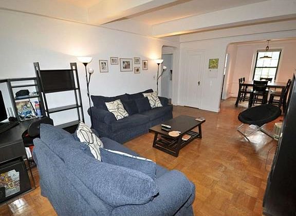 The living room looks out at the manicured courtyard and has an arched opening to the dining room. T