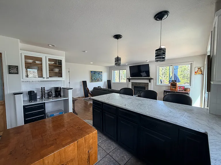 Kitchen area looking into living area with gas fireplace, (just flip the switch and you have a fire) stunning views with no neighbors on the west side of the home. 1.2 acres of usable land