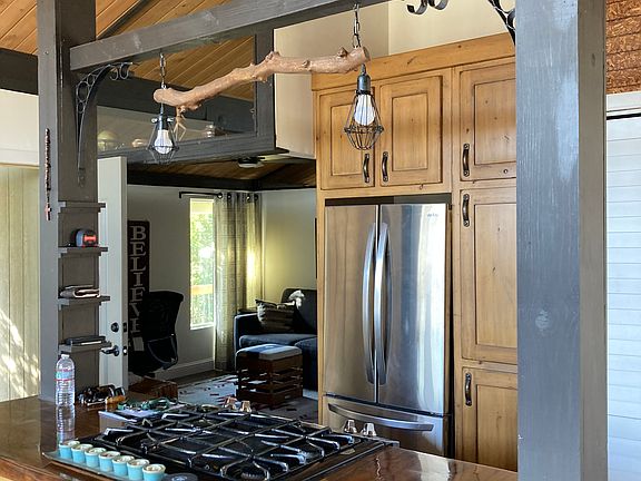 Gas stove/in kitchen washer/dryer. Custom Cabinets, live edge custom wood counters.