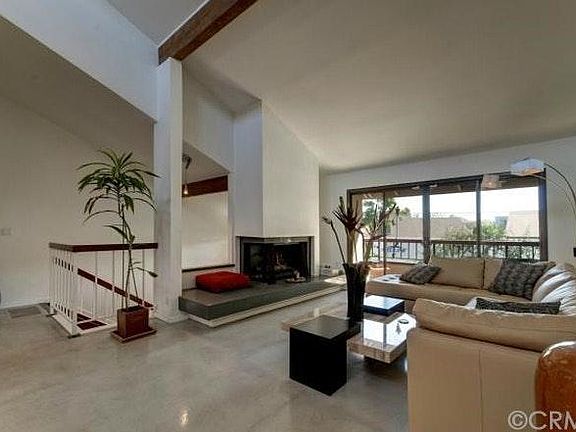 Living room, gas fireplace, balcony, and stairway to second