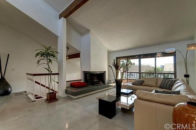 Living room, gas fireplace, balcony, and stairway to second