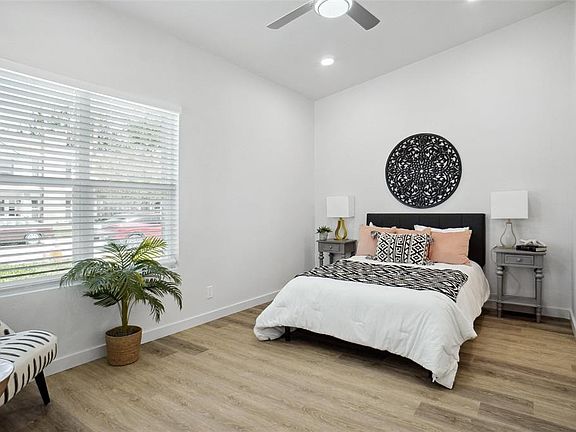 Bedroom featuring baseboards, vaulted ceiling, recessed lighting, ceiling fan, and wood finished floors