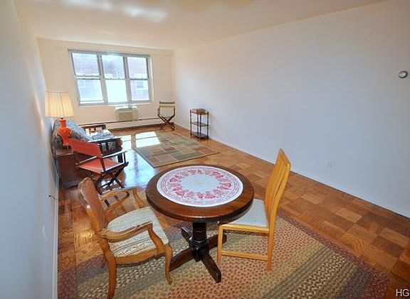 Large sunny living room with dining area and refinished parquet floors.