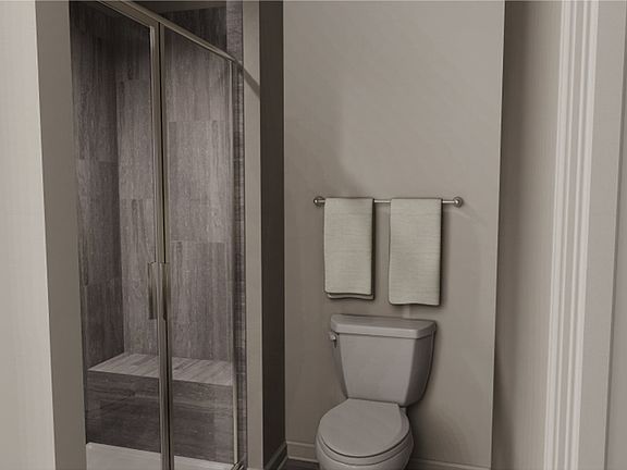 The glass-enclosed shower features a convenient seat