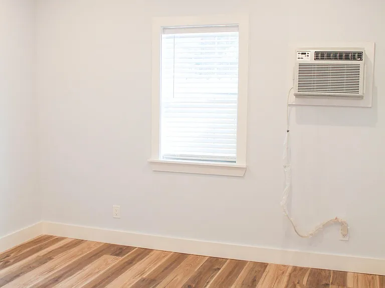 Large 12x12 bedroom. Natural lighting through wood blinds, large ceiling fan and recessed lighting. AC/Heater wall unit.