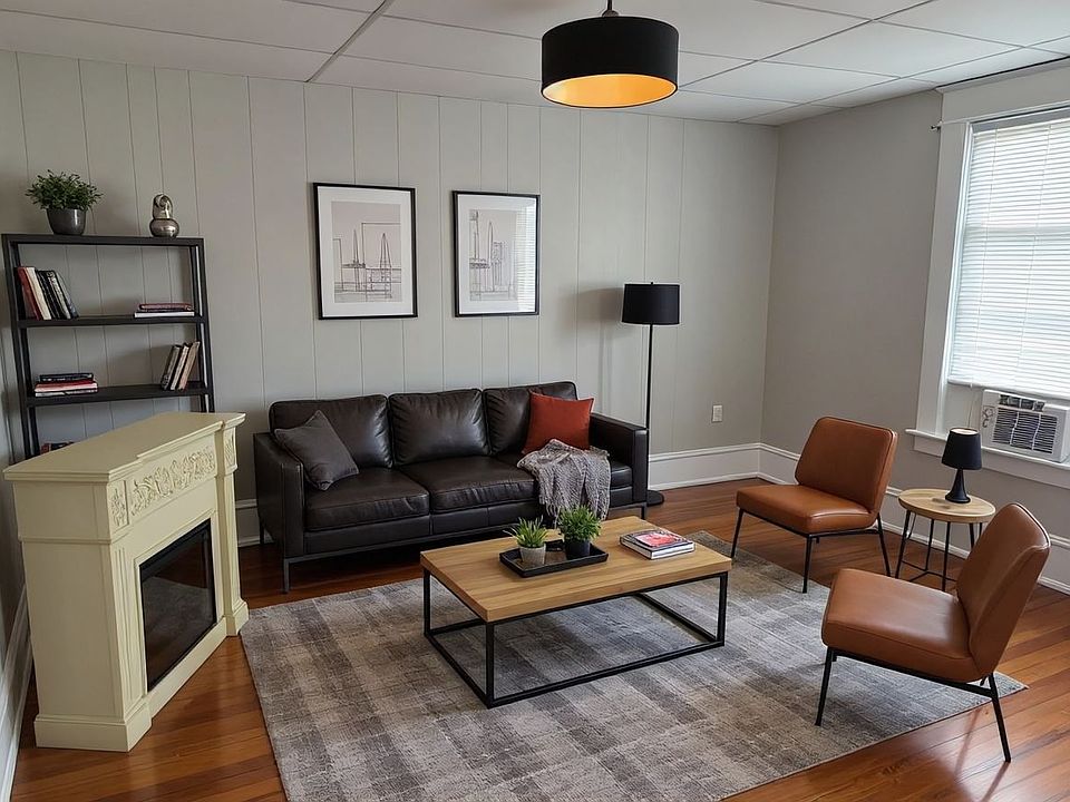 Spacious Living Room with Original Harwood Floors, Designer Lighting and New Sherwin Williams Ammonite Gray Paint Throughout.