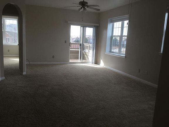 Large living dining area with two ceiling fans.