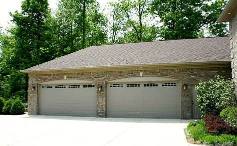 Over-sized 4-car finished garage w/ service door, bump out, and hobby/workshop space.