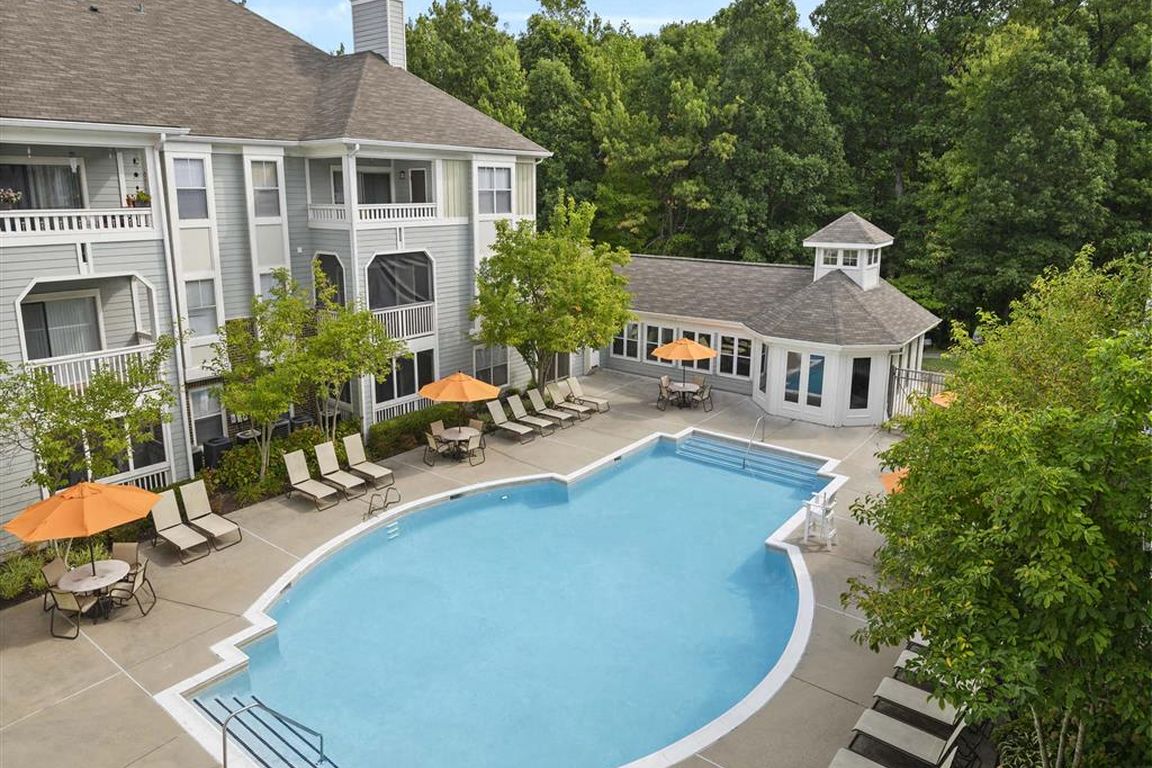 Resort-style swimming pool surrounded by greenery
