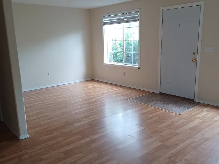 Front door and living area with bathroom off to the left.