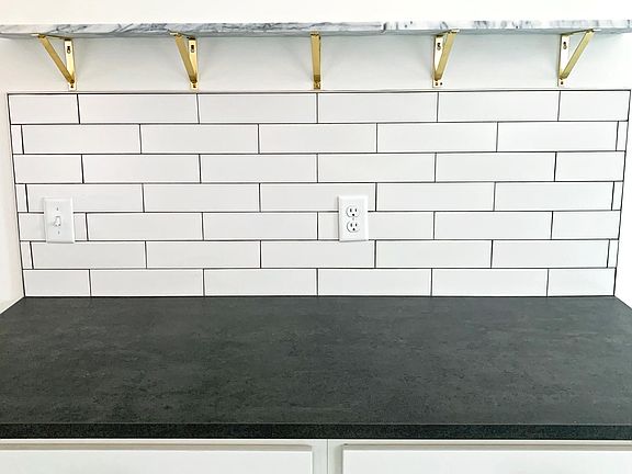 Beautiful galley kitchen with marble floating wall shelves.