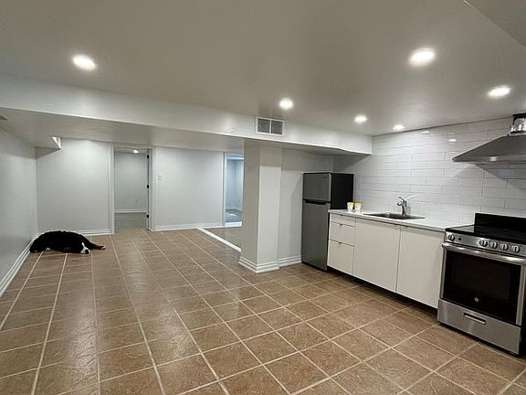 open-concept main room with kitchen/living/den/dining space